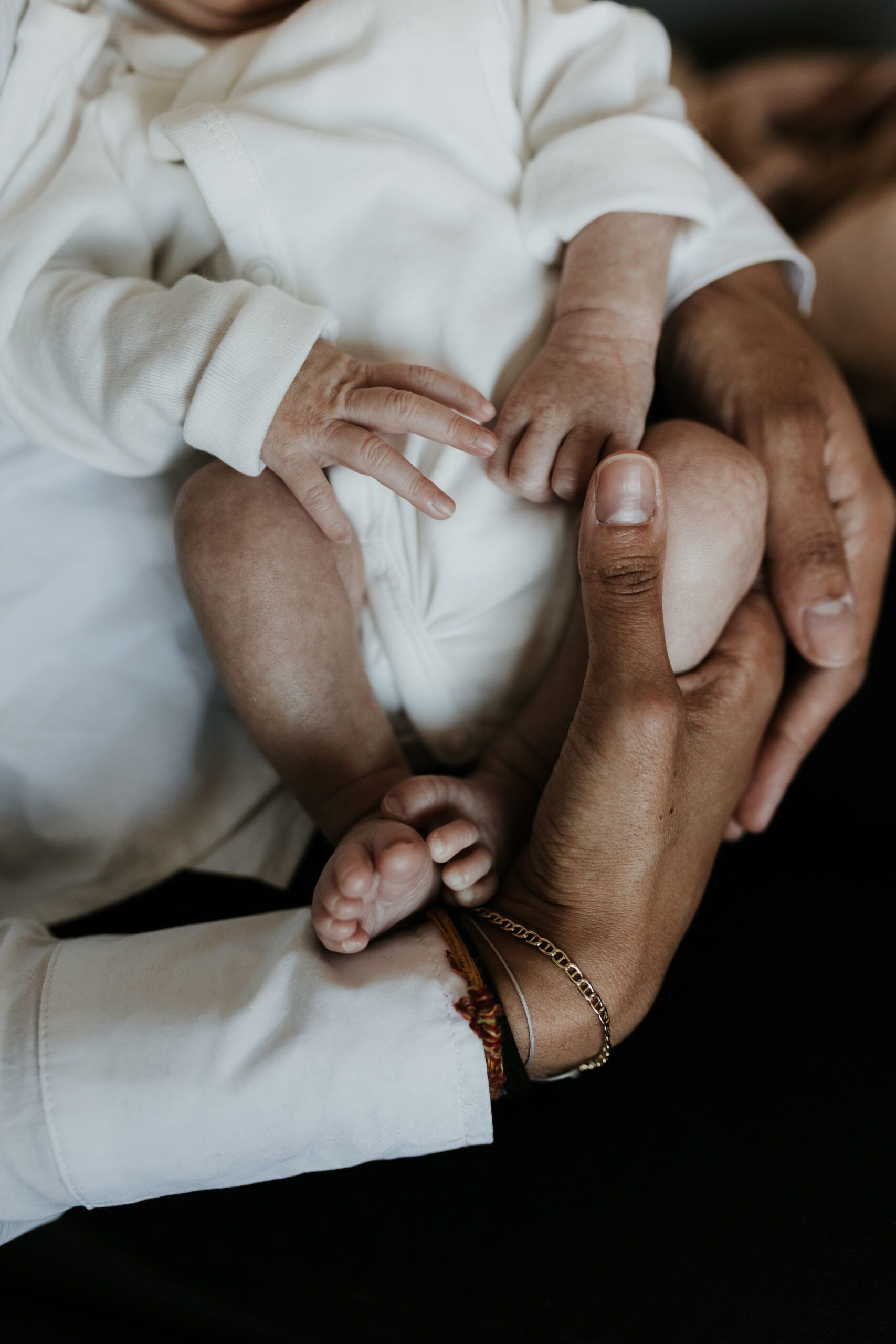 détails de petits pieds de bébé mêlés aux bras du papa