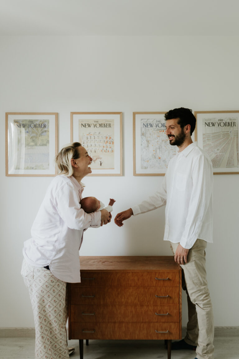 Un couple complice se regarde avec bébé dans les bras